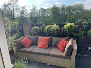 a couch with colorful pillows sitting on a patio at East Cliff in Preston