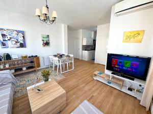 a living room with a large flat screen tv at L'hirondelle bleue in Tunis +4 photos
