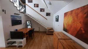 a living room with a table and a staircase at Apartmán Franz Josef in Hošťka