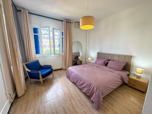 a bedroom with a bed and a blue chair at L'hirondelle bleue in Tunis