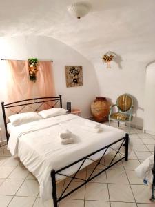 a bedroom with a large bed and a chair at Mani Tsopakas Residences Nest studio in Kafióna