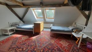 a attic room with two beds and a rug at Apartmán Franz Josef in Hošťka