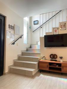 a living room with stairs with a tv and a table at Oasis in Montemorelos