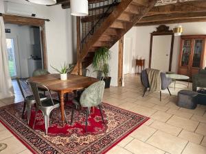 a dining room with a wooden table and chairs at Maison de campagne 110m2 in Longeault