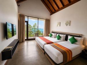 a bedroom with a large bed and a large window at Zen Koggala by Sugar Coliving in Habaraduwa Central +30 photos