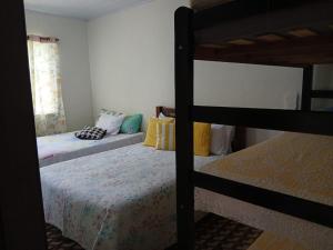a bedroom with two bunk beds and a window at Casa do Bem Viver in Trindade