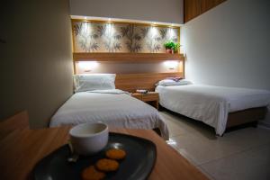 a hotel room with two beds and a tray of food on a table at Romea Aparthotel in Cesena