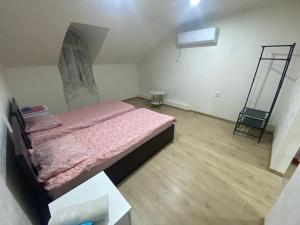 a small bedroom with a bed and a mirror at Marita Guesthouse in Batumi