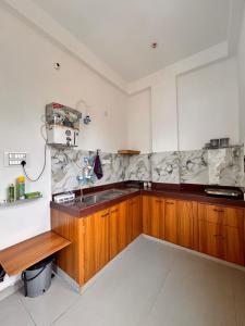 a kitchen with wooden cabinets and a sink at Mangal Uday Villa in Jaipur +41 photos