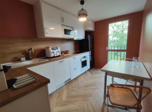a kitchen with white cabinets and a wooden floor at Appartement à Anglet in Anglet