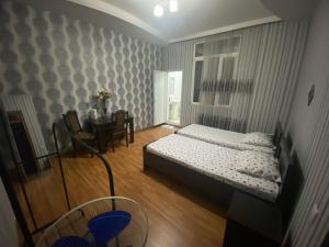 a small bedroom with a bed and a table at Marita Guesthouse in Batumi