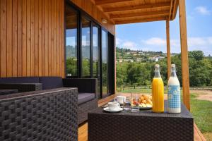 an outdoor table with two bottles of orange juice at Cabañas Compostela - Cabaña Sarela in Santiago de Compostela