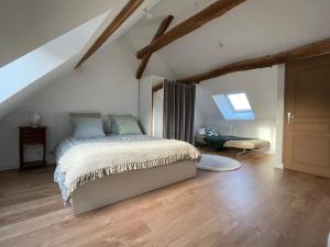 a bedroom with a bed in a attic at Maison de campagne 110m2 in Longeault