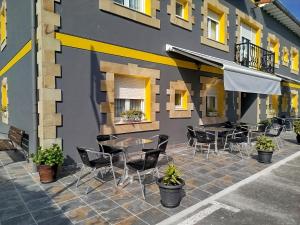 a patio with tables and chairs in front of a building at Posada Gran Sol in Queveda