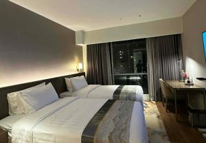 a hotel room with a large bed and a desk at Novotel Suites Celestia at Hotel Residences Manila in Manila