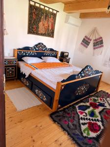 a bedroom with a bed in a room with a rug at La Patru Daci in Ocna Şugatag +170 photos