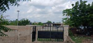 a gate in a brick wall with a fence at DeBoss Arena in Abeokuta