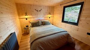 a bedroom with a bed in a wooden cabin at Lake District Woodland Cabin - Close to Ambleside & Langdale Valley in Ambleside