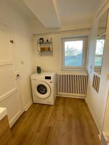 a laundry room with a washing machine and a window at Maison de campagne 110m2 in Longeault