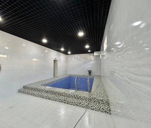 a bathroom with a blue tub in a white wall at Hotel Al Amir palace boutique in Bukhara