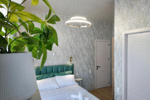 a bedroom with a green bed and a potted plant at Green Corner Kutaisi in Kutaisi