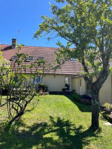 a house with a tree in the yard at Maison de campagne 110m2 in Longeault