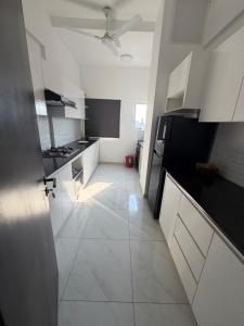 a kitchen with white cabinets and a white tile floor at Colombo lotus tower view Apartment in Colombo