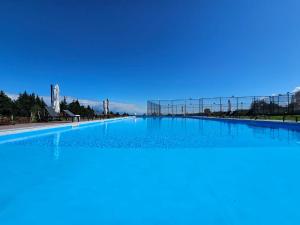 a large swimming pool with a blue sky in the background at Sunset Telavi in Telavi