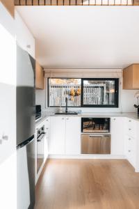 a kitchen with white cabinets and a large window at Alpine Chalet - views, fire-pit, central, cosy in Wanaka