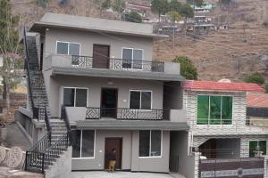 a man standing in front of a house at Royal Cottage in Murree in Murree