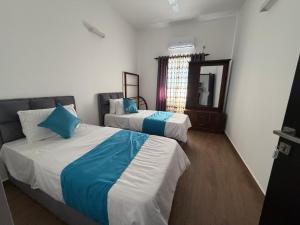 a bedroom with two beds with blue and white sheets at Colombo lotus tower view Apartment in Colombo