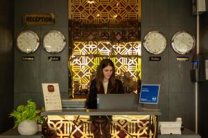 a woman sitting at a desk with a laptop at Denis Hotel Tbilisi in Tbilisi City
