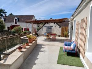 a patio with a table and chairs and a pergola at La Georginette in Saint-Georges-sur-Cher