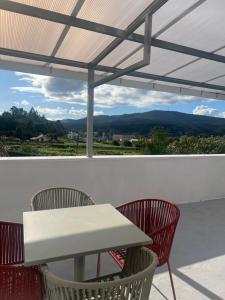 a white table and chairs on a patio with a view at pensión Palongo in Caldas de Reis