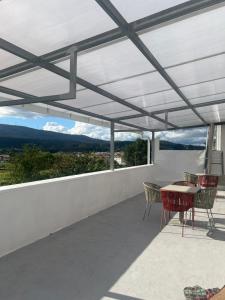 a patio with a white roof with chairs and a table at pensión Palongo in Caldas de Reis
