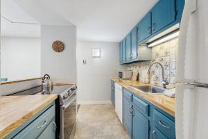 a kitchen with blue cabinets and a sink at Butternut Hill D5 in Waitsfield