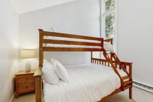 a bedroom with a wooden bed and a window at Butternut Hill D5 in Waitsfield +30 photos