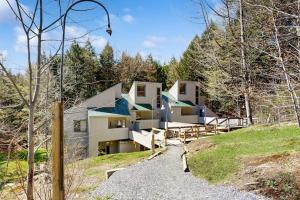 a building on a hill with trees in the background at Butternut Hill D5 in Waitsfield