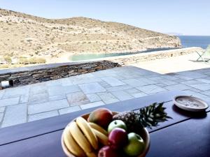 a bowl of fruit on a table with a view of the ocean at Marilia Village Spathi kea "Studio Melissa" in Spathi  +4 photos
