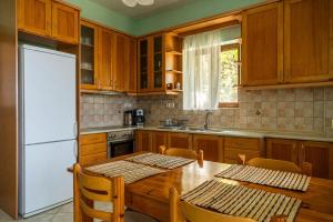 a kitchen with a wooden table and a white refrigerator at Villa Aethra in Riglia