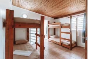 a room with two bunk beds in a house at Sacado Moorea Auberge de jeunesse Youth Hostel non climatisé no AC in Irioa