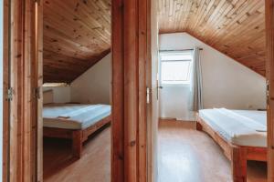 two beds in a small room with a window at Sacado Moorea Auberge de jeunesse Youth Hostel non climatisé no AC in Irioa