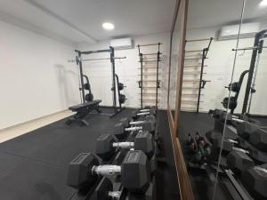 a gym with rows of equipment in a room at Bumblebee apartments & rooms with pool in Novalja