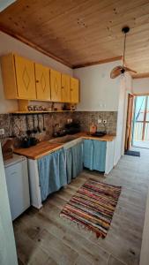 a kitchen with yellow cabinets and a rug on the floor at BlePelagos house in Glossa
