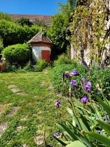 a garden with purple flowers and a red door at Le Clos Verdonnais in Verdon