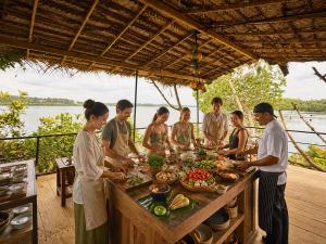 a group of people standing around a table with food at Zen Koggala by Sugar Coliving in Habaraduwa Central