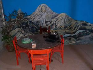a table with two chairs and a painting on the wall at 7 duendes in Salta