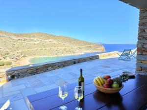 a table with a bowl of fruit and a bottle of wine at Marilia Village Spathi kea "Studio Melissa" in Spathi 
