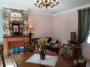 a living room with a table with a vase on it at La Georginette in Saint-Georges-sur-Cher