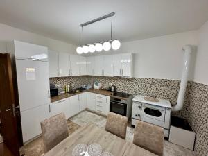 a kitchen with white cabinets and a table and chairs at White Hill in Ulcinj +34 photos